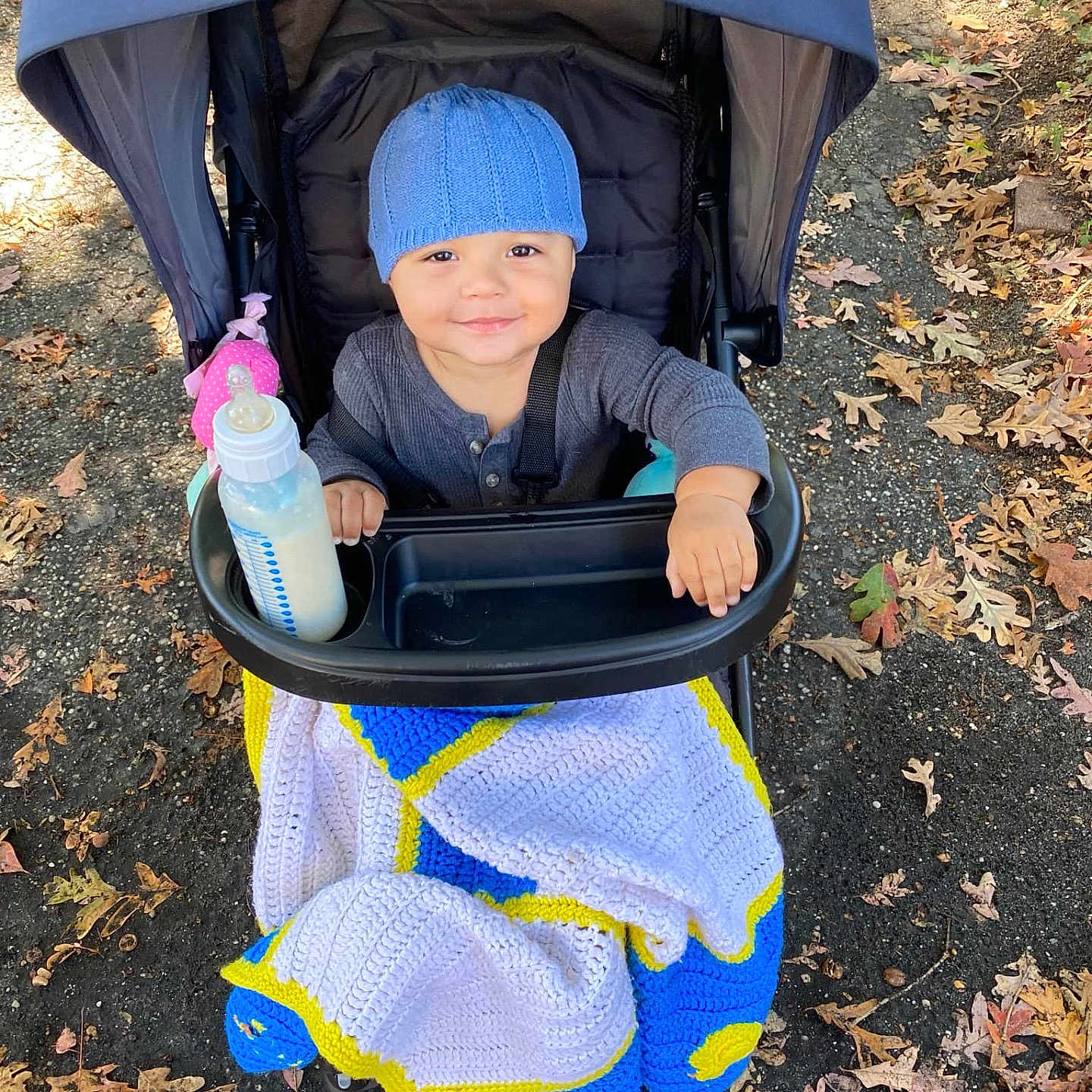 Adriel is registered to the contest to win money with this photo: accessories, architecture, baby, blanket, building, cap, clothing, face, happy, hat, head, outdoors, person, photography, portrait, pushing, shelter, sitting, smile, stroller
