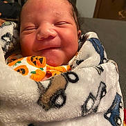 Steven is registered to the contest to win money with this photo: baby, blanket, closed_eyes, couch, cozy, cute, face, hair, head, indoor, infant, newborn, onesie, patterned_blanket, portrait, pumpkin_print, sleepy, smiling, soft_texture, swaddled