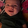 baby, smiling, infant, face, clothing, blanket, floral_pattern, striped_pattern, lying_down, happy, cute, child, indoors, portrait, skin, hand, head, toddler, dark_green, fabric