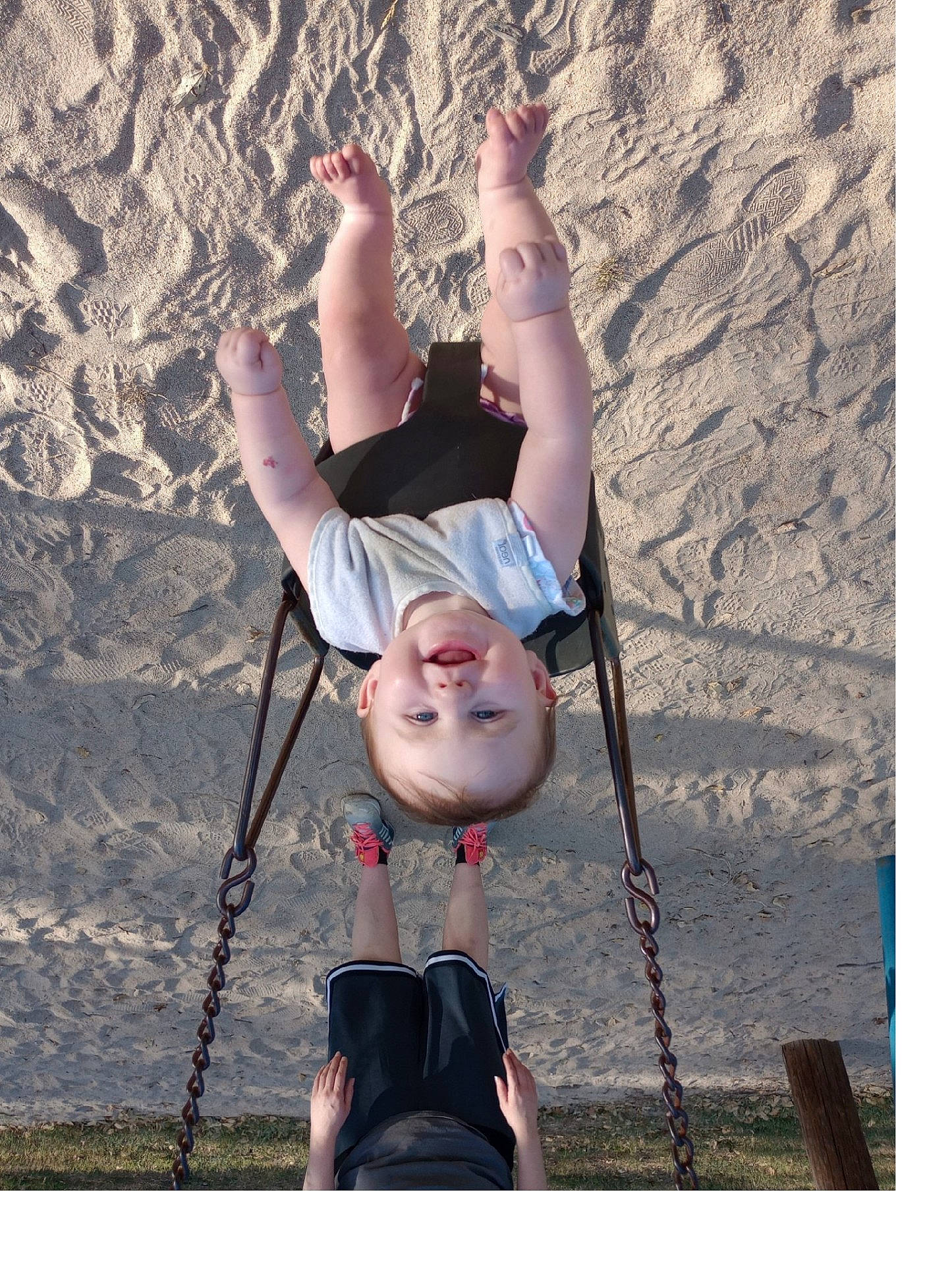 Grace is registered to the contest to win money with this photo: baby, clothing, face, footwear, grass, head, nature, outdoorplayarea, outdoors, park, person, photography, plant, playarea, portrait, sandal, shoe, soil, swing, toy