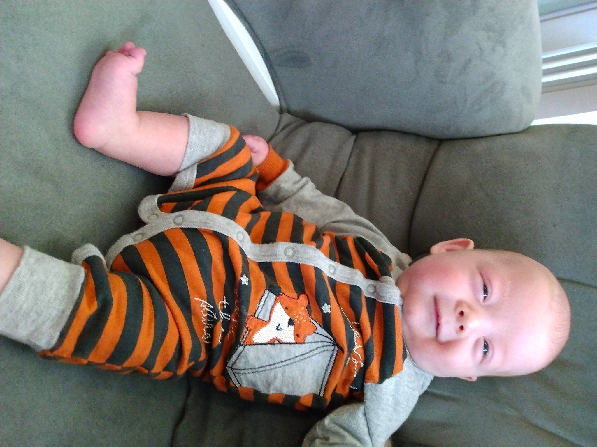 Kaiden joined the competition — help win amazing prizes! baby, baby_products, baby_toddler_clothing, child, comfort, finger, flooring, headgear, human_leg, mouth, orange, pattern, person, sitting, skin, sleeve, sock, textile, toddler, white