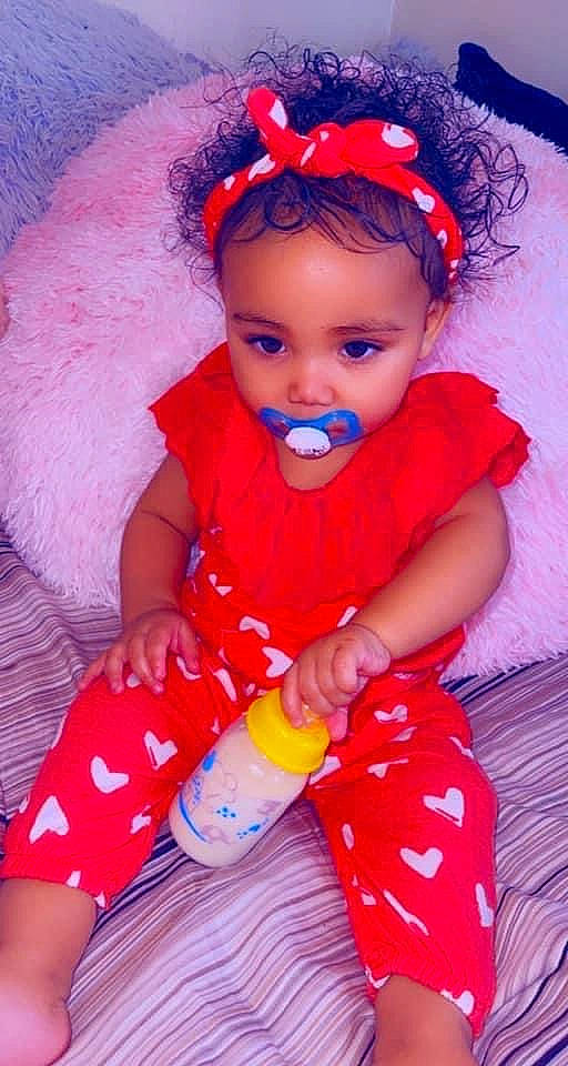 Leilani is registered to the contest to win money with this photo: baby, baby_toddler_clothing, cheek, child, dress, hairstyle, happy, head, iris, lip, orange, organ, people, person, pink, purple, red, skin, sleeve, textile