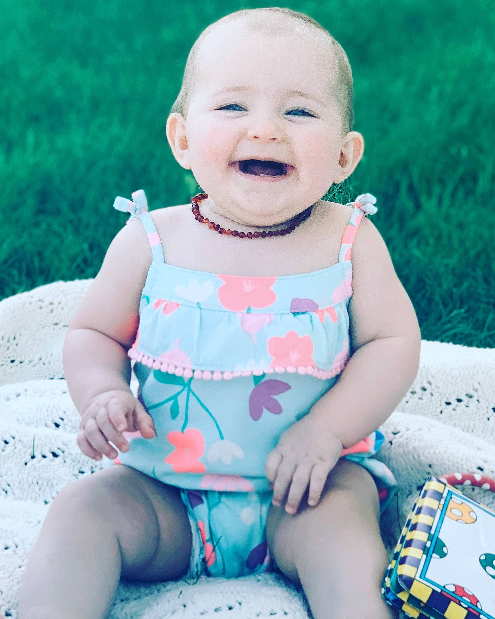 Ronnie is registered to the contest to win money with this photo: baby, baby_toddler_clothing, beauty, blue, cheek, child, design, face, facial_expression, grass, head, joy, leg, lip, person, pink, product, sitting, skin, smile