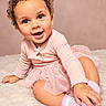 baby, bow, child, curly_hair, dress, fuzzy_socks, happy, indoor, infant, photography, pink_background, pink_outfit, portrait, rug, sitting, smiling, socks, soft_lighting, studio, tutu