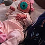 baby, pacifier, pink_bow, bottle, blanket, clothing, infant, sleeping, hand, face, lying_down, soft_surface, fabric, pattern, person, cute, newborn, indoors, resting, child