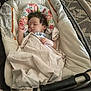 baby, sleeping, blanket, baby_seat, floral_pattern, infant, child, cute, cozy, indoors, resting, soft, toddler, peaceful, relaxed, portrait, person, head, hand, fabric