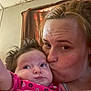 Layla is registered to the contest to win money with this photo: affection, baby, casual, child, close_up, curly_hair, expression, face, family, head, indoor, intimate, kiss, love, parent, person, pink_clothing, portrait, skin, woman