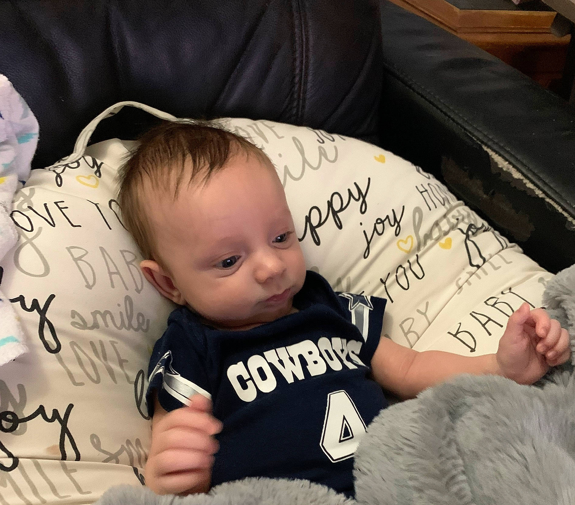 Jameson is registered to the contest to win money with this photo: baby, baby_toddler_clothing, black, cheek, child, comfort, cool, couch, finger, font, hairstyle, hand, handwriting, happy, people, person, photograph, product, t_shirt, toddler