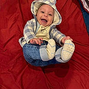 Noah joined the competition — help win amazing prizes! baby, smiling, hoodie, bear_ears, socks, jeans, red_blanket, happy, infant, cute, child, playful, clothing, portrait, indoor, person, baby_clothes, lying_down, cheerful, closeup