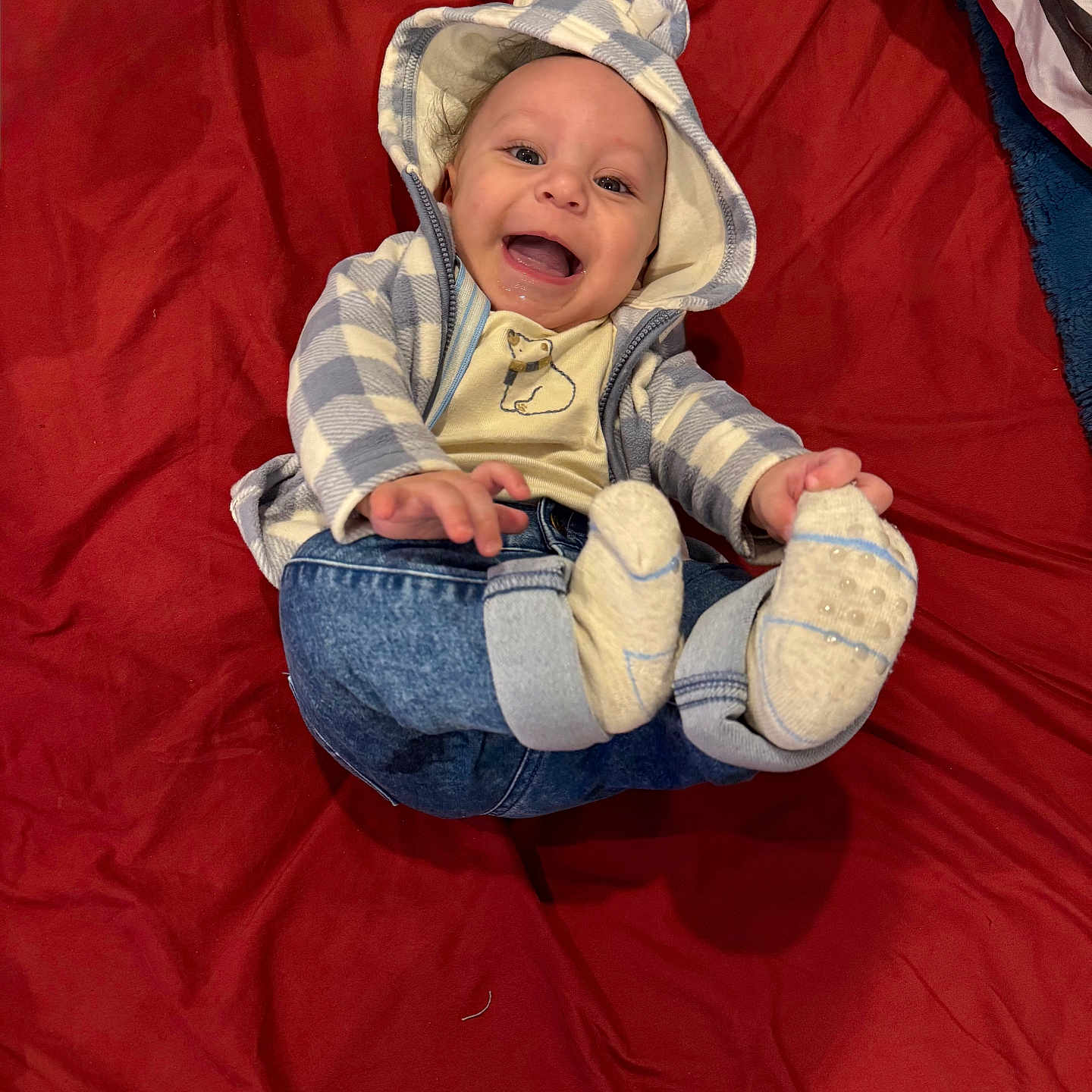 Noah joined the competition — help win amazing prizes! baby, baby_clothes, bear_ears, cheerful, child, closeup, clothing, cute, happy, hoodie, indoor, infant, jeans, lying_down, person, playful, portrait, red_blanket, smiling, socks