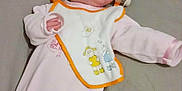 Ambre a rejoint le concours — aidez-le/la à gagner de superbes lots ! baby, infant, onesie, bib, pacifier, bed, gray_bedspread, sleepwear, cartoon_animals, clothing, lying_down, soft_fabric, child, cute, relaxed, indoors, resting, person, young, sleep