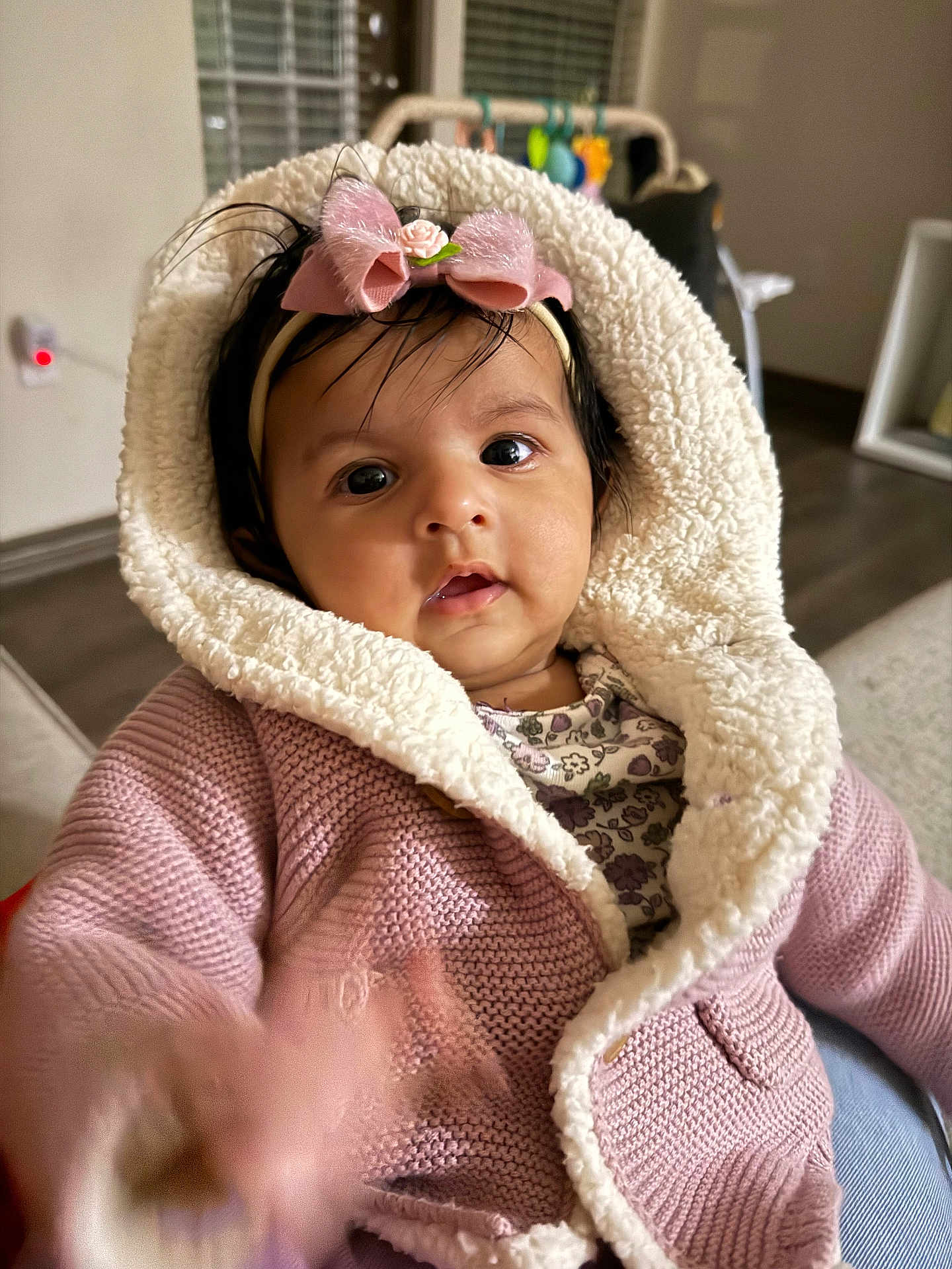 Zara is registered to the contest to win money with this photo: baby, child, pink_jacket, headband, bow, indoor, cozy, curious, knitted, hood, infant, person, portrait, cute, hand, face, expression, soft, warm, toy