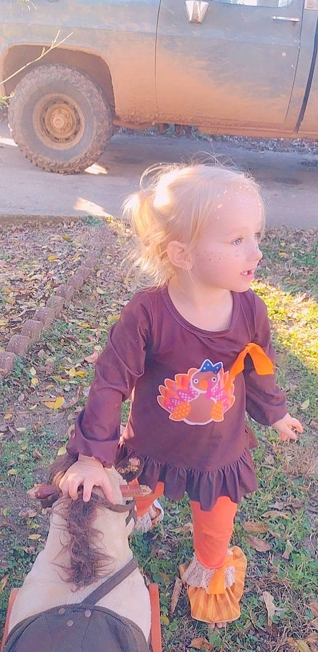 Blakelynn is registered to the contest to win money with this photo: asphalt, automotive_tire, baby_toddler_clothing, grass, happy, leaf, light, orange, people_in_nature, person, photograph, pink, sleeve, summer, synthetic_rubber, tire, toddler, tread, vertebrate, wheel