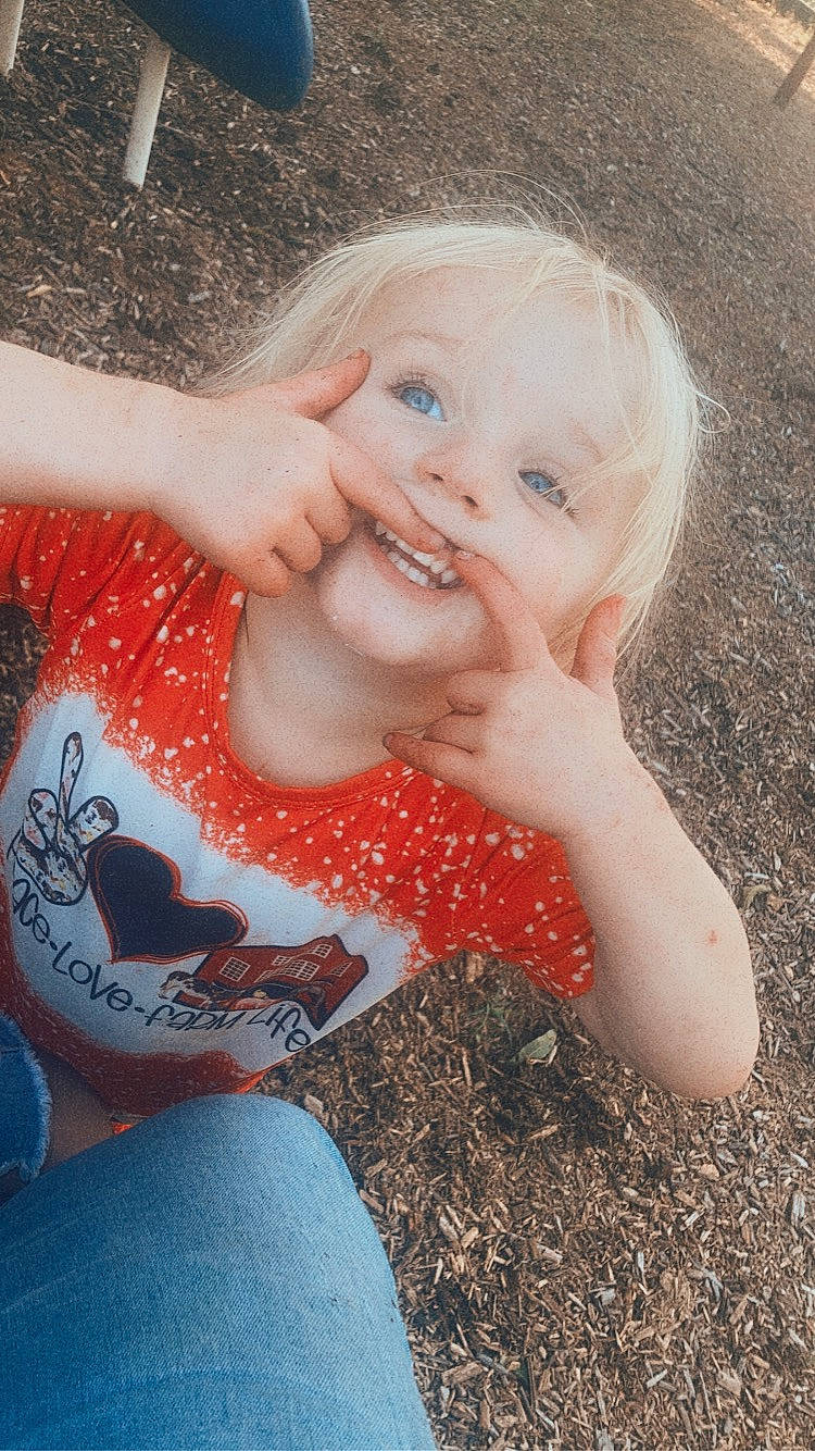 Blakelynn is registered to the contest to win money with this photo: arm, baby, baby_toddler_clothing, child, eye, finger, fun, gesture, grass, hand, happy, jeans, joy, lip, mouth, nose, people_in_nature, person, skin, smile