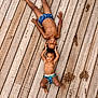 child, children, boy, boys, smiling, playful, barefoot, swim_trunks, wooden_deck, outdoor, summer, siblings, happy, skin, face, hands, legs, feet, water_spots, fun