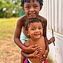 child, children, boy, smile, happy, outdoor, grass, curly_hair, embrace, play, stick, summer, bare_chest, shorts, nature, portrait, friendship, fun, sibling, daylight