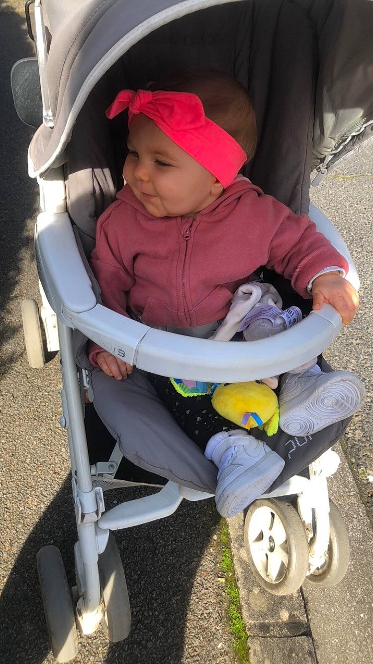 Kaëly participe au concours pour gagner de l'argent avec cette photo : baby, baby_carriage, baby_products, baby_toddler_clothing, baseball_cap, cap, child, comfort, face, fun, grass, hat, headwear, lap, person, personal_protective_equipment, product, recreation, sitting, tire
