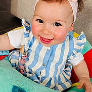 Gioia a rejoint le concours — aidez-le/la à gagner de superbes lots ! baby, blue_striped_dress, cheeks, child, clothing, colorful, cute, face, happy, headband, indoor, infant, person, pink_bow, plush_toy, portrait, seated, smiling, toy, young