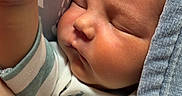 Mikah is registered to the contest to win money with this photo: baby, blanket, child, closeup, cozy, cute, face, fist, hair, hand, indoors, infant, newborn, onesie, peaceful, portrait, resting, skin, sleeping, soft