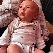 Rowdy joined the competition — help win amazing prizes! baby, infant, onesie, star_pattern, blanket, cozy, indoor, soft_texture, pout, cute, child, newborn, skin, hand, face, person, portrait, seated, clothing, expression