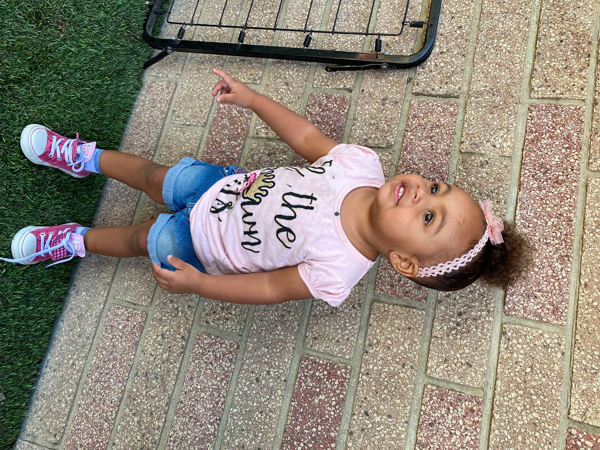 Amina is registered to the contest to win money with this photo: eyewear, flooring, fun, grass, happy, human_leg, joint, knee, leisure, mammal, pattern, person, road_surface, shoe, sportswear, sunglasses, t_shirt, thigh, vertebrate, waist