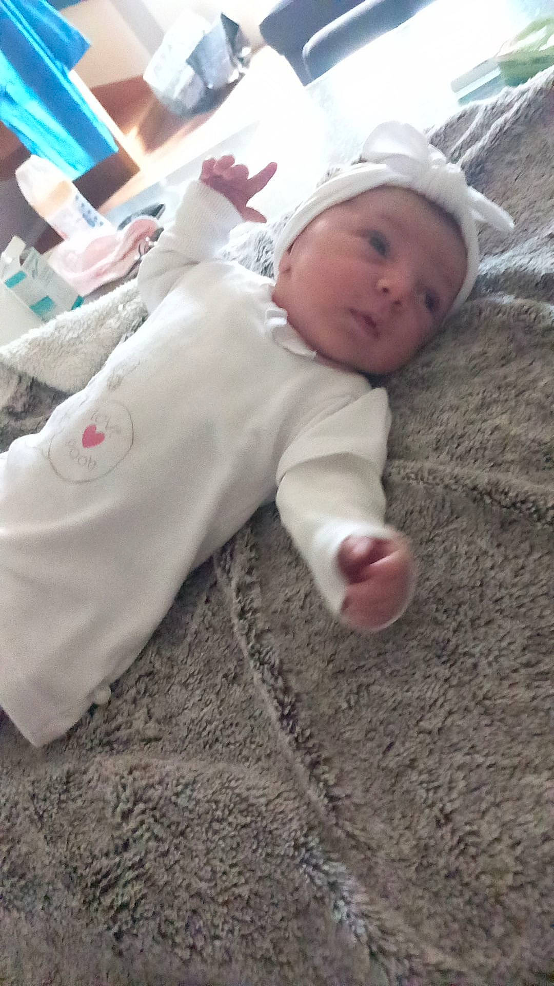 Gianna a rejoint le concours — aidez-le/la à gagner de superbes lots ! baby, baby_toddler_clothing, carmine, child, comfort, flooring, fur, grass, headwear, linens, person, sand, sitting, sleeve, soil, toddler, winter, wood, wool