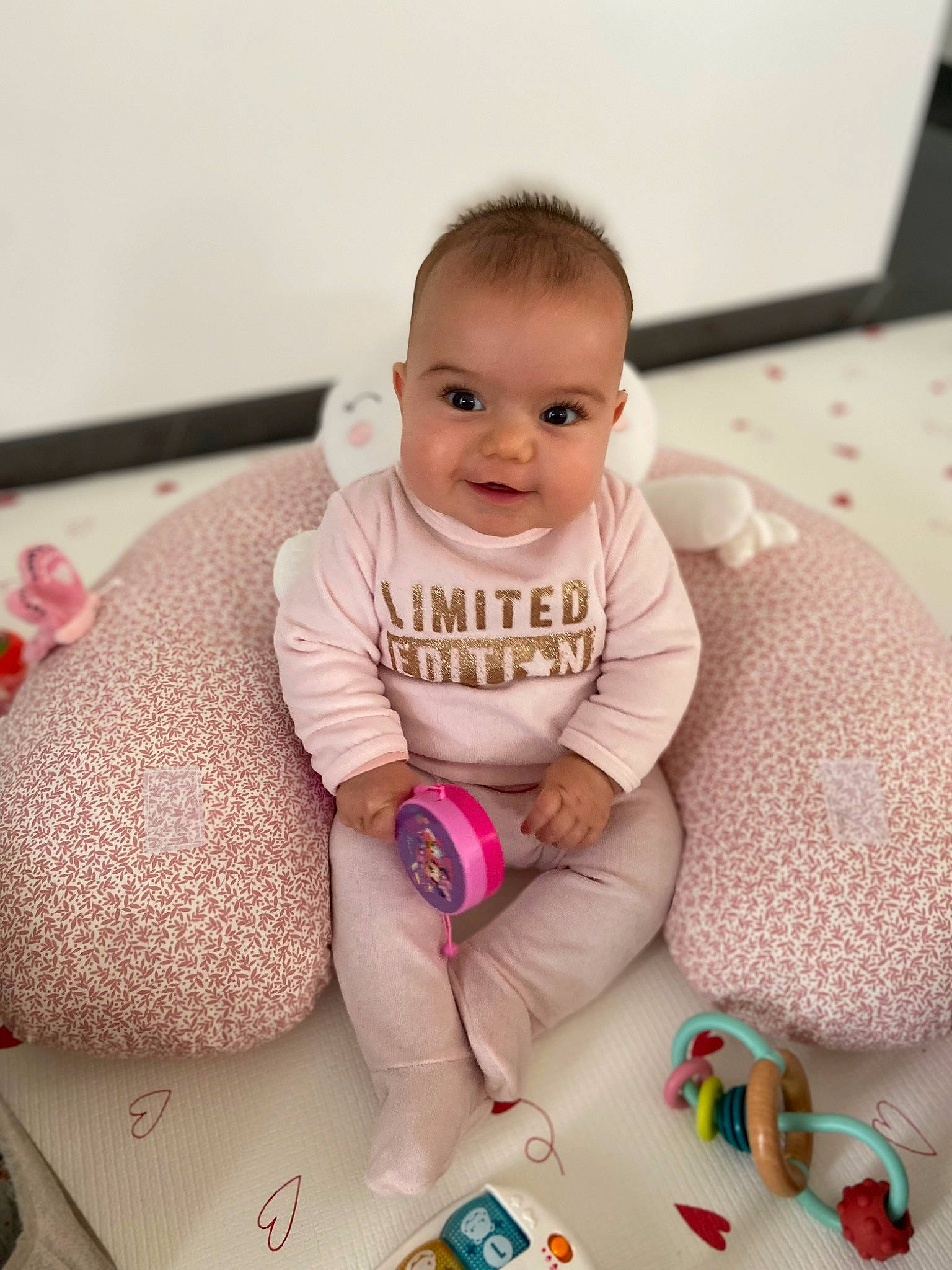 élia a rejoint le concours — aidez-le/la à gagner de superbes lots ! baby, baby_products, baby_toddler_clothing, cheek, child, comfort, flooring, foot, happy, knee, leg, nail, person, pink, sitting, skin, sleeve, smile, sock, thigh
