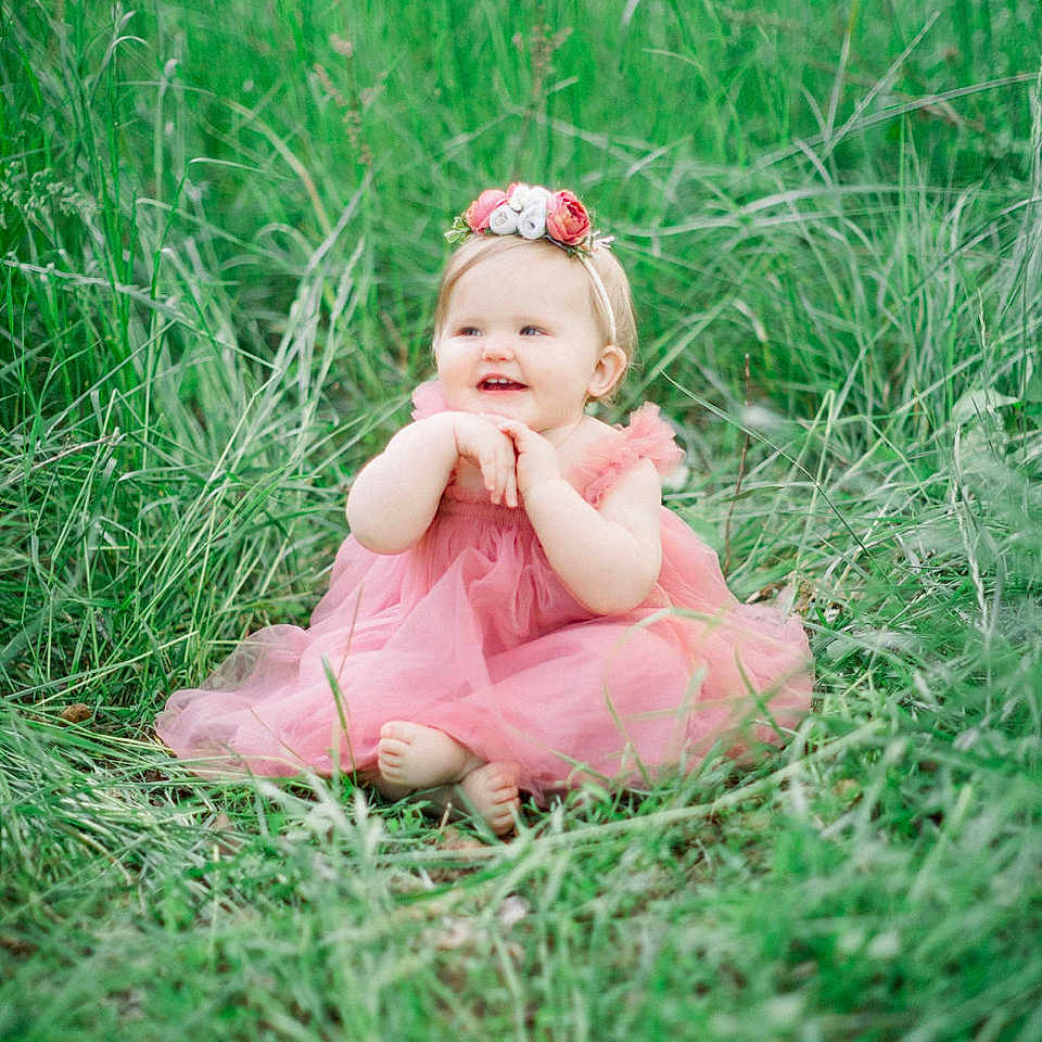 Elizabeth joined the competition — help win amazing prizes! accessories, baby, clothing, dress, face, field, flower, formalwear, grass, grassland, happy, head, lawn, nature, outdoors, person, photography, plant, portrait, sitting