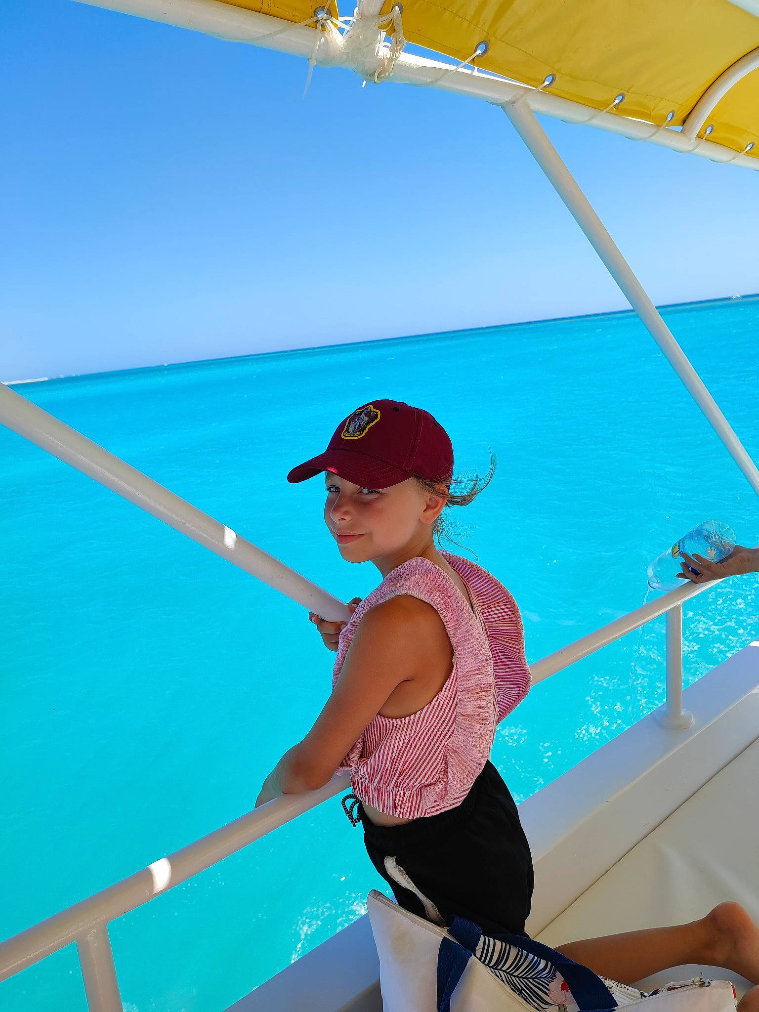 Lola a rejoint le concours — aidez-le/la à gagner de superbes lots ! azure, baseball_cap, boats_and_boating_equipment_and_supplies, cap, elbow, electric_blue, fun, hat, headwear, lake, leisure, outdoor_recreation, person, recreation, shade, shorts, sky, summer, thigh, travel