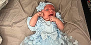 Dani is registered to the contest to win money with this photo: baby, bed, blanket, blue_outfit, butterflies, child, clothing, cute, flowers, hands, headband, indoors, infant, legs, lying_down, newborn, person, portrait, skin, soft_light