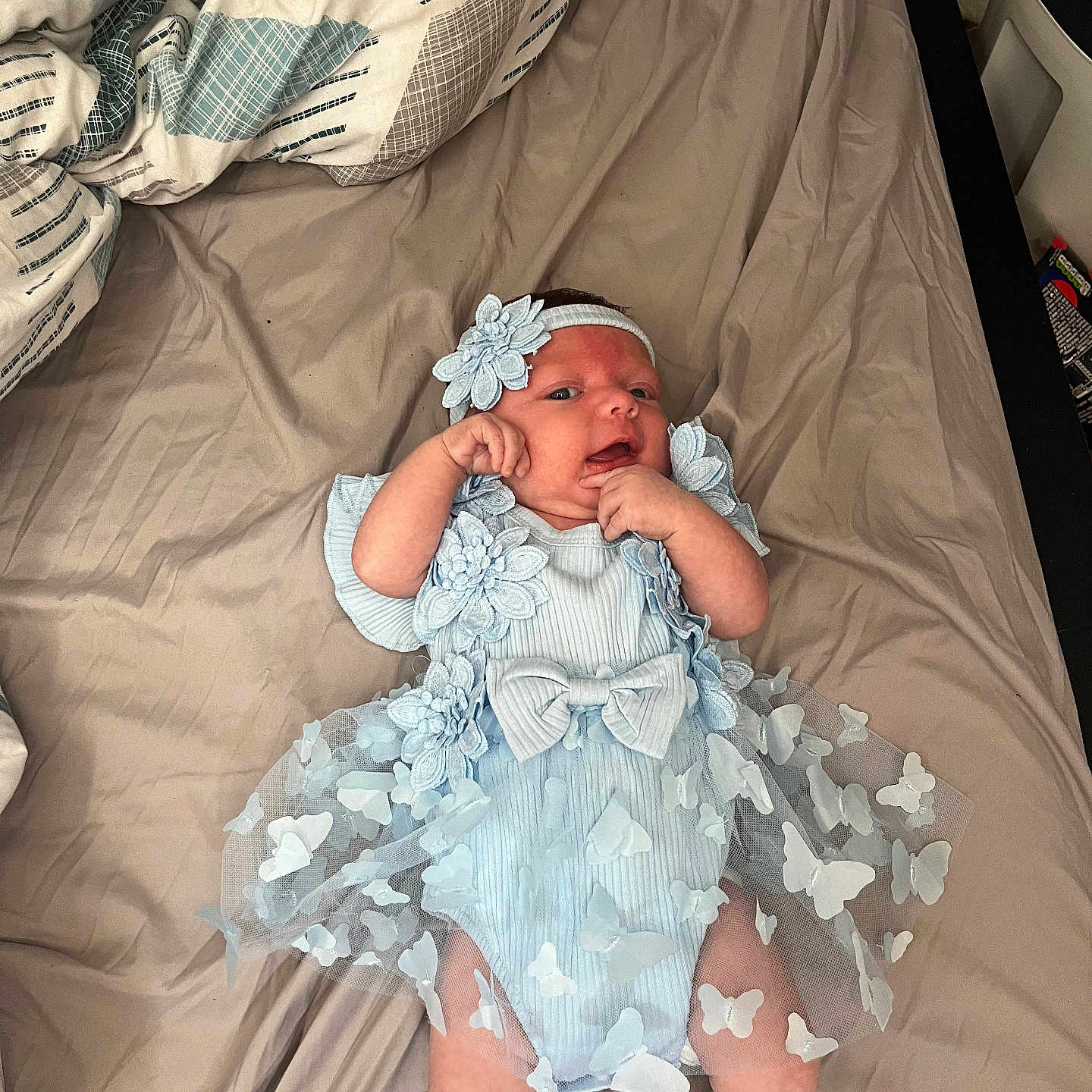 Dani is registered to the contest to win money with this photo: baby, bed, blanket, blue_outfit, butterflies, child, clothing, cute, flowers, hands, headband, indoors, infant, legs, lying_down, newborn, person, portrait, skin, soft_light