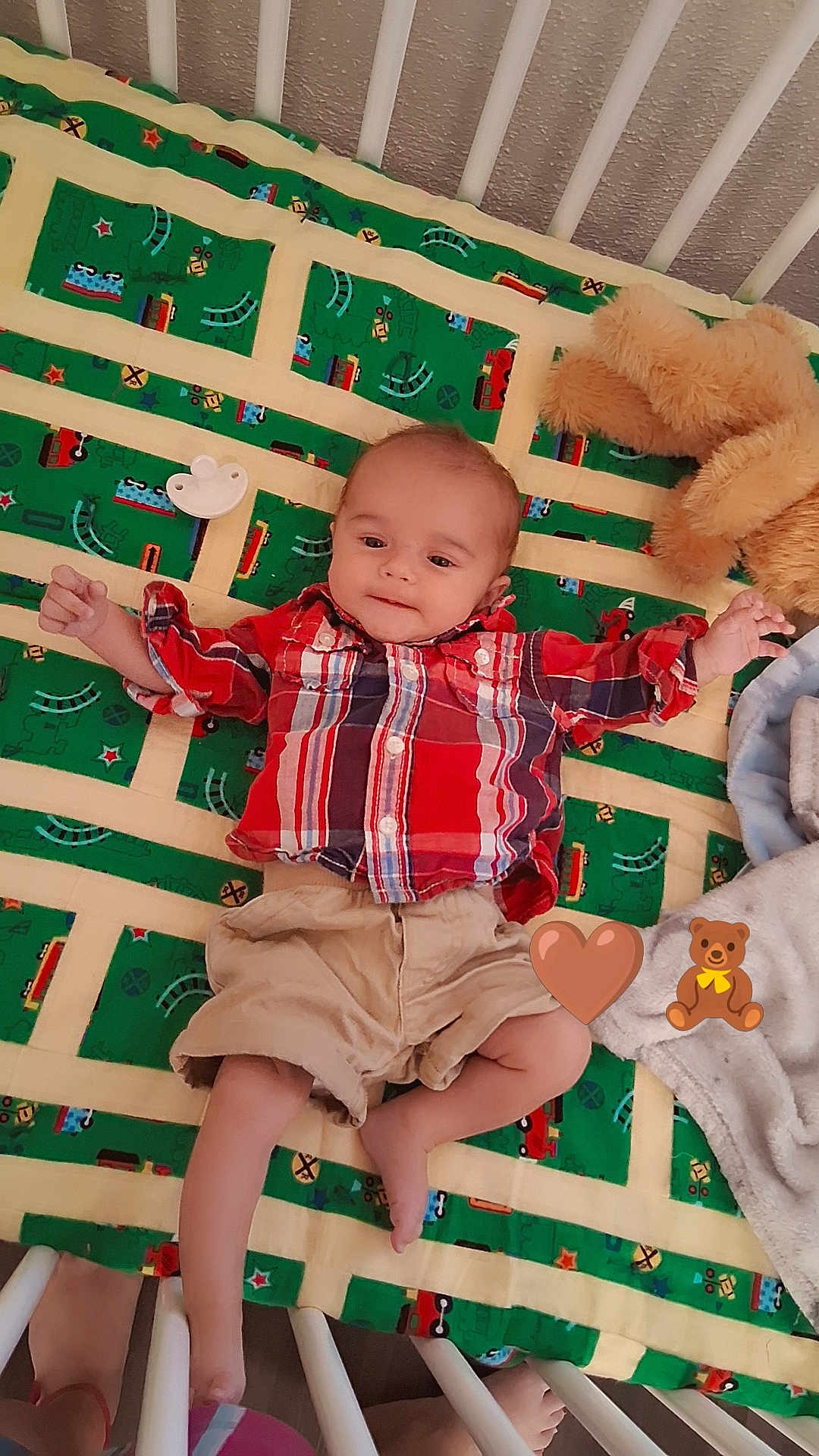 Robert joined the competition — help win amazing prizes! baby, infant, crib, blanket, plaid_shirt, shorts, teddy_bear, pacifier, child, cute, lying_down, colorful, pattern, toy, footwear, bed, fabric, comfort, playful, cozy
