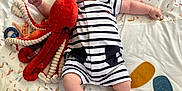 Jean participe au concours pour gagner de l'argent avec cette photo : baby, bed, blanket, child, comfort, cute, feather_pattern, happy, indoor, infant, leaf_pattern, lying_down, octopus, pajamas, person, playful, plush_toy, smiling, soft_toy, striped_clothing