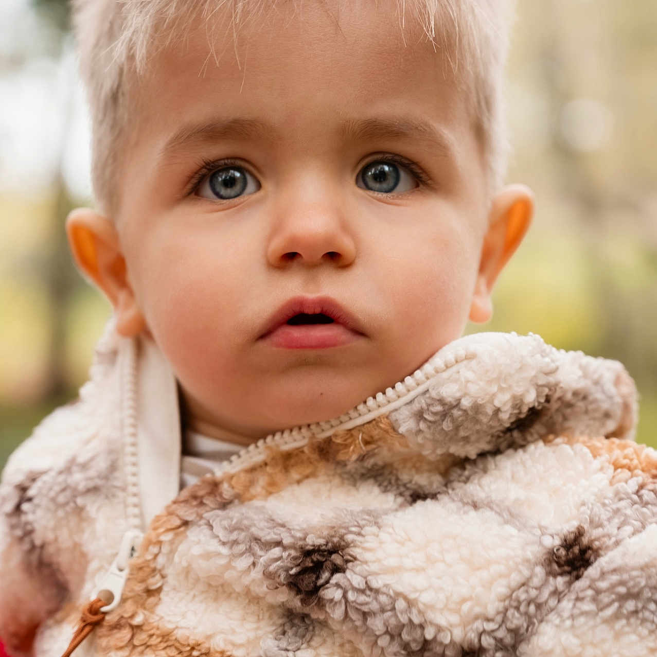 Marceau participe au concours pour gagner de l'argent avec cette photo : baby, blanket, bodypart, clothing, coat, face, finger, frown, fur, hand, happy, head, hoodie, knitwear, person, photography, portrait, smile, sweater, sweatshirt