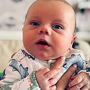 Sonny joined the competition — help win amazing prizes! baby, infant, close_up, hand, holding, curious, expression, patterned_clothing, soft_colors, portrait, child, cute, skin, face, newborn, person, indoor, young, looking, small_hands