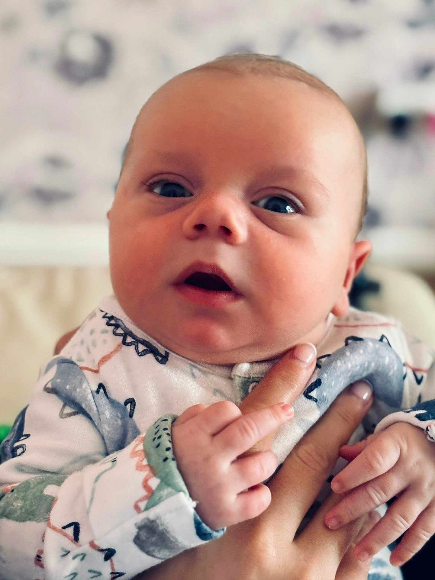 Sonny joined the competition — help win amazing prizes! baby, infant, close_up, hand, holding, curious, expression, patterned_clothing, soft_colors, portrait, child, cute, skin, face, newborn, person, indoor, young, looking, small_hands