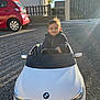 Julio a rejoint le concours — aidez-le/la à gagner de superbes lots ! automobile, baby, bmw, car, child, cute, daylight, driveway, front_view, happy, jacket, outdoor, person, play, small_car, smiling, sunlight, toddler, toy_car, vehicle