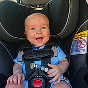 Ansen joined the competition — help win amazing prizes! baby, car_seat, smiling, child, infant, seatbelt, safety, blue_clothing, happy, person, vehicle_interior, car_window, adult_face, head, hand, cute, closeup, daylight, straps, seat