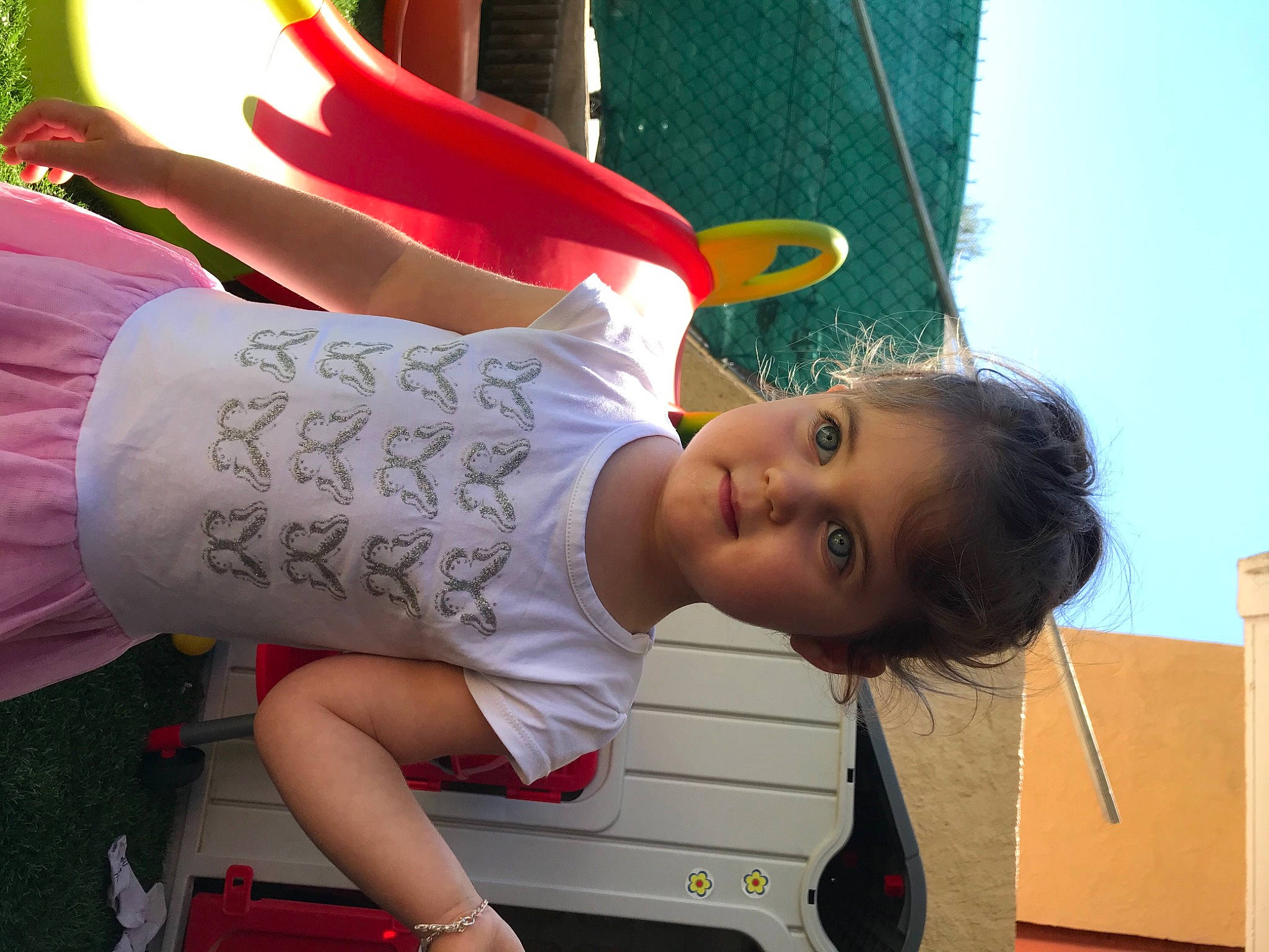 Kélya participe au concours pour gagner de l'argent avec cette photo : baby, child, fun, grass, happy, hat, human_leg, knee, leg, leisure, person, pink, plant, play, recreation, sandal, shorts, sitting, t_shirt, thigh