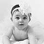 Clélia participe au concours pour gagner de l'argent avec cette photo : baby, black_and_white, blanket, child, closeup, curious, cute, expression, face, flower, headband, infant, innocence, lying_down, person, portrait, skin, soft_texture, toddler, young