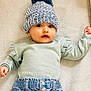 Alyana is registered to the contest to win money with this photo: baby, infant, hat, knitted_hat, pom_pom, sweater, ruffles, denim_pants, clothing, blanket, soft_texture, lying_down, cute, face, portrait, child, young, indoor, warm, expression