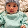 baby, child, infant, knit_hat, pom_pom, blue_sweater, clothing, cute, face, wide_eyes, hand, jeans, soft_blanket, indoor, portrait, warm_clothing, young_child, sitting, cozy, expression