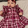 Alyana is registered to the contest to win money with this photo: baby, child, infant, plaid_dress, headband, bow, pink, burgundy, ruffles, soft_surface, blanket, texture, curious, cute, portrait, indoor, cozy, clothing, person, lying_down