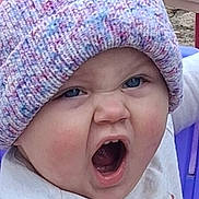 Journee is registered to the contest to win money with this photo: baby, child, face, hat, knit_hat, expression, mouth_open, blue_eyes, clothing, purple_chair, pink_table, outdoor, cute, playful, portrait, person, infant, funny_expression, close_up, headwear