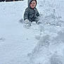 child, toddler, snow, winter, outdoor, cold, snowsuit, hood, gloves, sitting, smiling, face, snowy_ground, footprints, backyard, brick_wall, tree, play, daylight, cozy