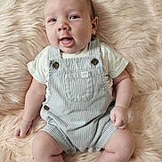 Sawyer joined the competition — help win amazing prizes! baby, infant, smiling, overalls, striped_clothing, furry_rug, soft_texture, happy, cute, child, portrait, skin, legs, arms, sitting, face, mouth_open, light_skin, indoors, cozy
