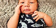 Sawyer is registered to the contest to win money with this photo: baby, blanket, child, clothing, curious, cute, expression, face, hand, head, indoors, infant, lying_down, onesie, person, portrait, shark_pattern, skin, texture, young_child