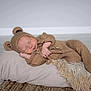 baby, sleeping, knitted_clothing, bear_costume, pillow, blanket, soft_texture, cozy, cute, infant, child, resting, floor, indoor, portrait, peaceful, warm, hand, headwear, cuteness