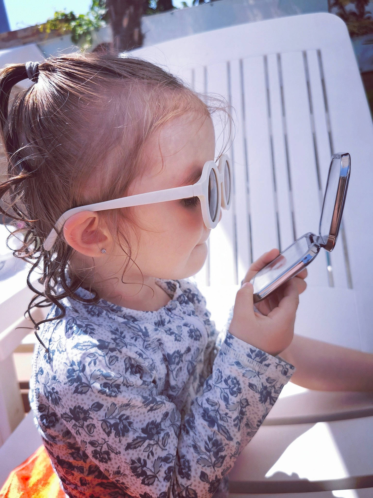 Eleonor participe au concours pour gagner de l'argent avec cette photo : blond, child, cool, electronic_device, eyewear, fashion_accessory, fun, gadget, human, mobile_phone, office_equipment, office_instrument, office_supplies, person, sitting, snapshot, summer, technology, toddler, vision_care