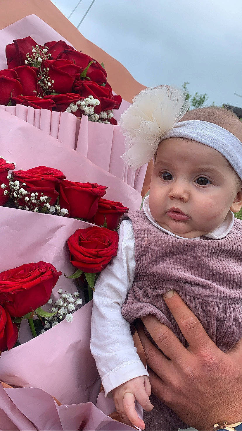 Azelya participe au concours pour gagner de l'argent avec cette photo : baby, baby_toddler_clothing, cap, cut_flowers, event, fashion, flower, flower_arranging, garden_roses, happy, headwear, hybrid_tea_rose, person, petal, pink, plant, product, rose, rose_family, rose_order